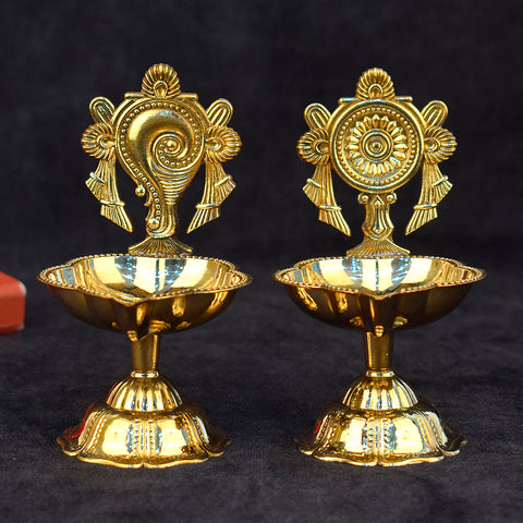 Elegant pair of designer Shankh and Chakra brass diyas, beautifully handcrafted for spiritual rituals, pooja ceremonies, and festive decoration. India’s Largest Pooja Accessories Brand – www.satvikworld.com