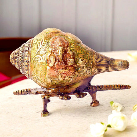 Handcrafted Indian Brass Shankh with intricate Lord Ganesha engraving, beautifully mounted on a sturdy brass stand. This decorative conch shell is ideal for home temples, pooja rituals, and festive décor. A perfect blend of spirituality and artistry, it adds sacred elegance to any space. India’s Largest Pooja Accessories Brand – www.satvikworld.com